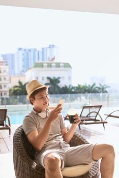 Summer sunny day, cheerful attractive smile asian man uses the smartphone