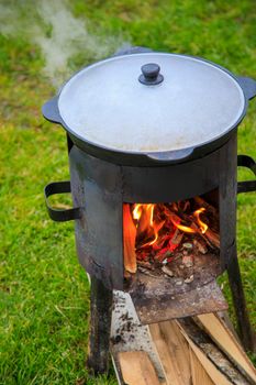 Cooking in a cauldron on the fire. Picnic outdoors in summer. Close-up