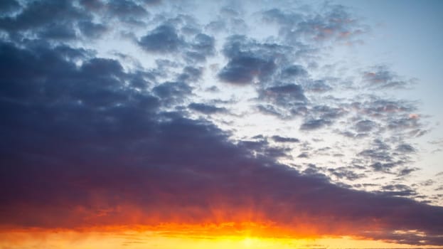 Colorful sunset or sunrise in the sky. The sky and clouds are painted in different delicate colors.