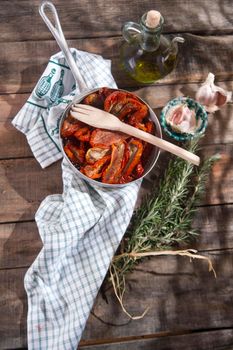 Presentation portion of dried tomatoes with rosemary in small colander