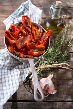 Presentation portion of dried tomatoes with rosemary in small colander