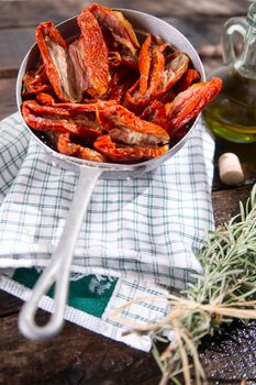 Presentation portion of dried tomatoes with rosemary in small colander