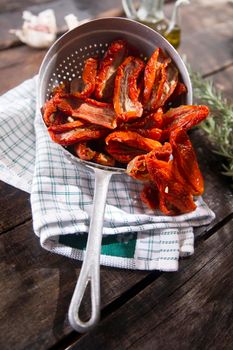 Presentation portion of dried tomatoes with rosemary in small colander