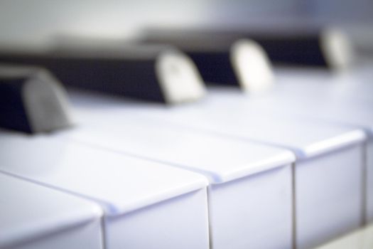 Part of the keyboard of a piano in white color. No people
