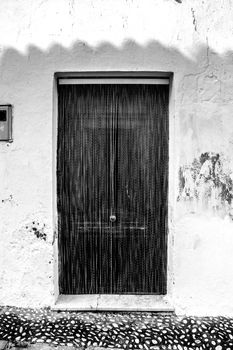 Striped metal curtain on door of village house in Altea, Alicante, Spain