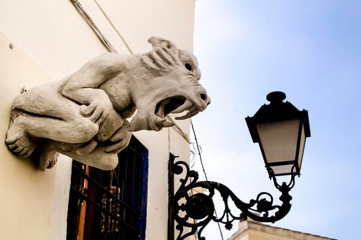 Facade with decorative ceramic monster and vintage streetlight in Altea village, Alicante, Spain
