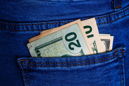 Banknotes close up, money in a jeans pocket. Dollars stick out of the jeans pocket, finance and currency concept. Concept of saving or spending money