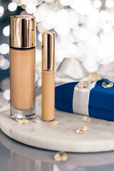 Cosmetic branding, Christmas glitter and girly blog concept - Holiday make-up foundation base, concealer and blue gift box, luxury cosmetics present and blank label products for beauty brand design