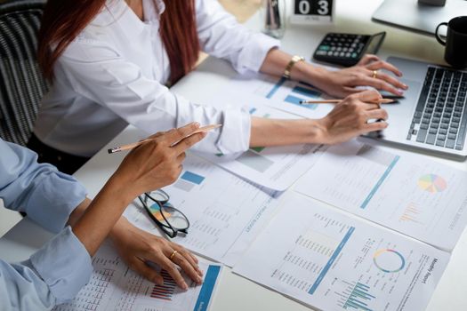 Two colleagues discussing with document data and calculator on desk table. Close up business team analysis and strategy concept.