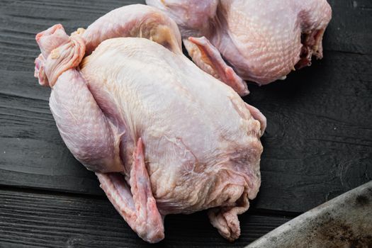 Raw organic uncooked whole chicken meat, on black wooden background