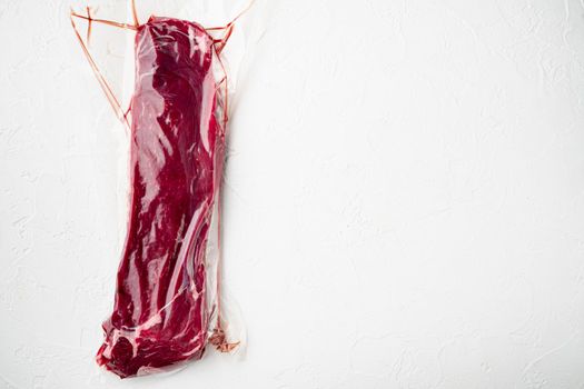Sirloin beef steak in vacuum packaging. Market pack set, on white stone background, top view flat lay, with copy space for text