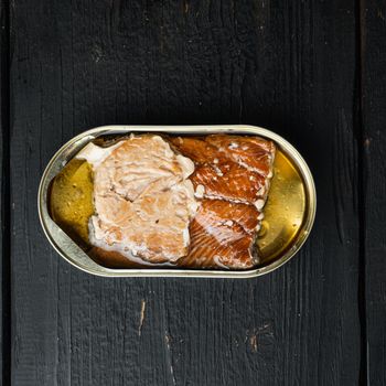 Wild Pink Salmon Canned smoked fish set, in tin can, on black wooden table background, top view flat lay, square format