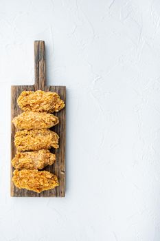 Fried chicken wings parts on white background, flat lay, with space for text.