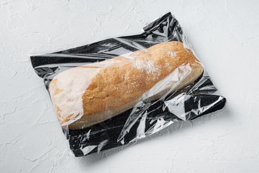 Loaf of fresh baked artisan whole grain ciabatta bread in a market bag, on white background