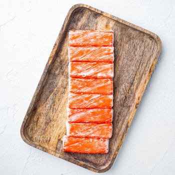 Fresh Crab meat stick surimi with blue swimming crab set, on wooden tray, on white background, top view flat lay