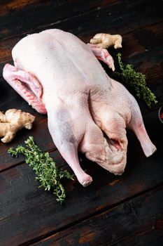 Raw whole mallard duck meat on dark wooden background.
