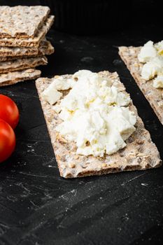 Homemade Crisp bread toast with Cottage Cheese set, on black dark stone table background, with copy space for text