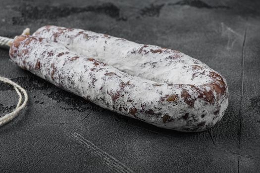 Dry salami sausage fuet on grey textured background.