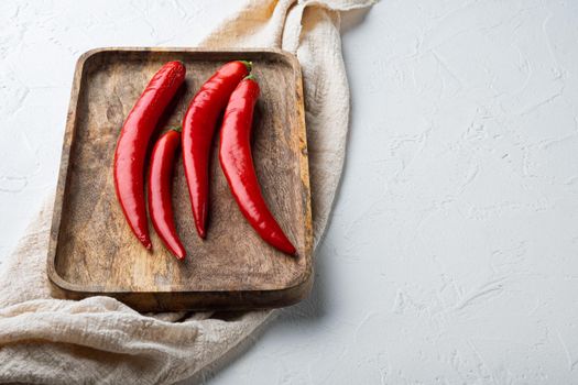 Raw red chili pepper set, on white textured background with space for text