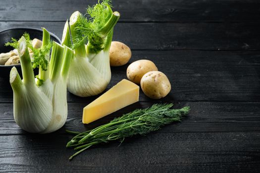Artichoke with fennel, potato and parmesan ingredient, on black wooden table with space for text