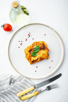 Italian Food. Hot Tasty Freshly Baked Lasagna set, on plate, on white stone background, top view, flat lay