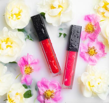 Lip gloss and rose. Lipstick. Beautiful lips. Decorative cosmetics . Well-groomed face. Makeup. Cosmetics without labels. Flowers