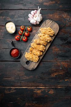 Fried chicken wings parts on old dark wooden table, top view, with copy space.