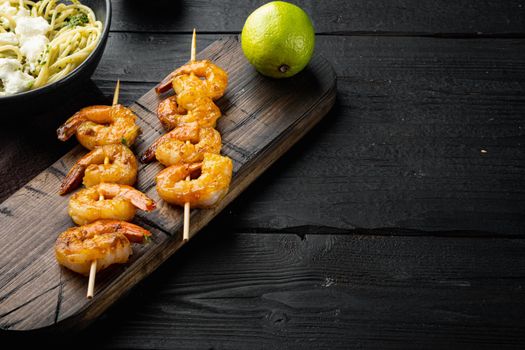 Traditional Italian dish. pasta with pesto ricotta parmesan and grilled seafood set, on black wooden table background , with copyspace and space for text