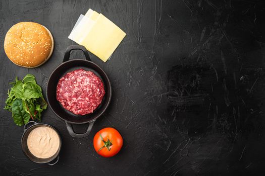 Raw Ground beef meat Burger steak cutlets with ingredients and buns set, on black stone background, top view flat lay, with copy space for text