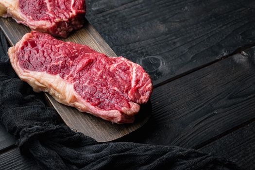 Top loin, fresh organic beef meat cut, on black wooden table, with copy space for text
