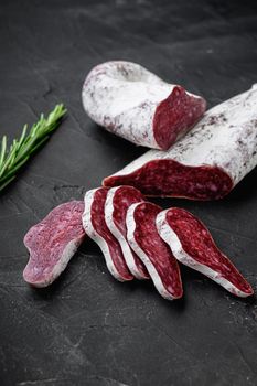 Longaniza, traditional salami spanish sausage on black textured surface.
