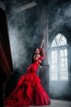 Woman Vintage Red Dress Old Castle Beautiful Princess In Seductive Dress Elegant Caucasian Female Fairy Tale story Near Big Window With Smoke Fog