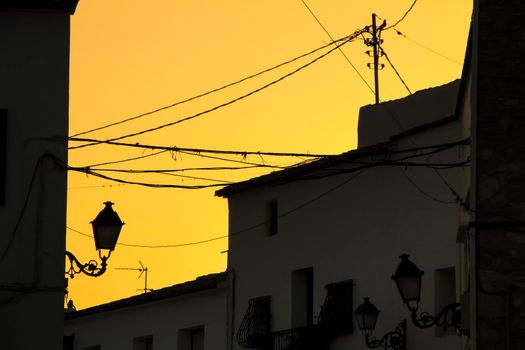 Orange sunset with houses and streetlight silhouettes in Altea, Alicante, Spain in summer