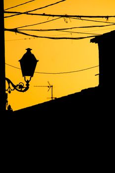 Orange sunset with houses and streetlight silhouettes in Altea, Alicante, Spain in summer