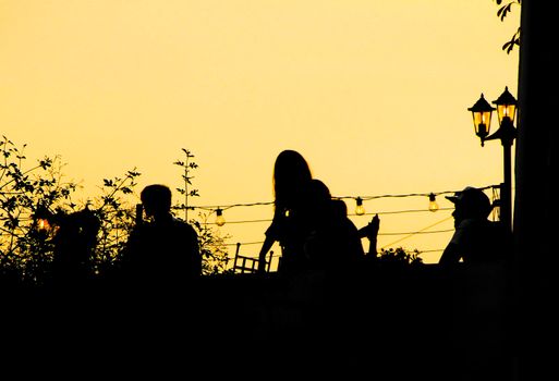 People enjoying and relaxing in a rooftop in Altea village at sunset in summer