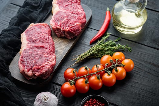 Veiny steak, marbled beef raw meat, on black wooden background