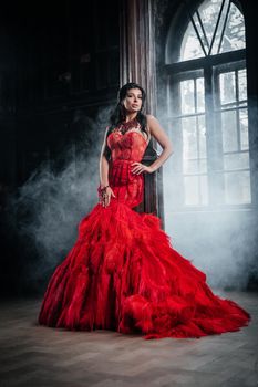 Woman Vintage Red Dress Old Castle Beautiful Princess In Seductive Dress Elegant Caucasian Female Fairy Tale story Near Big Window With Smoke Fog