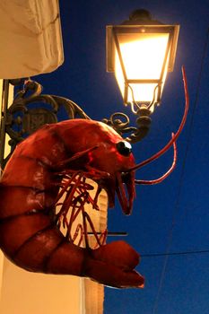 Decorative ceramic prawn and vintage streetlight on the facade of a house in Altea village, Alicante, Spain