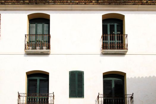 Whitewashed facade with window with forged metal grill and vintage streetlight in Altea village, Alicante, Spain