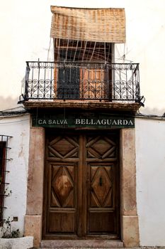 Altea, Alicante, Spain- June 1, 2021:Facade with wooden door and balcony with forged metal grill in Altea village, Alicante, Spain