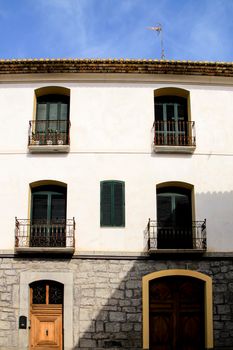 Whitewashed facade with window with forged metal grill and vintage streetlight in Altea village, Alicante, Spain