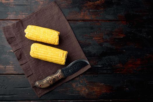 Homemade golden sweet corn cob set, on old dark wooden table background, top view flat lay, with copy space for text