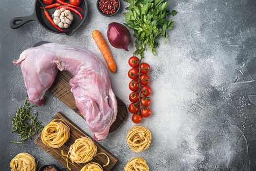 Fresh meat. Whole rabbit ready to cook stew tagliatelle set, on gray stone background, top view flat lay, with copy space for text