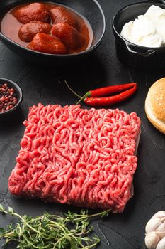 Home Raw Minced Beef Meatball burgers ingredients set, on black stone background