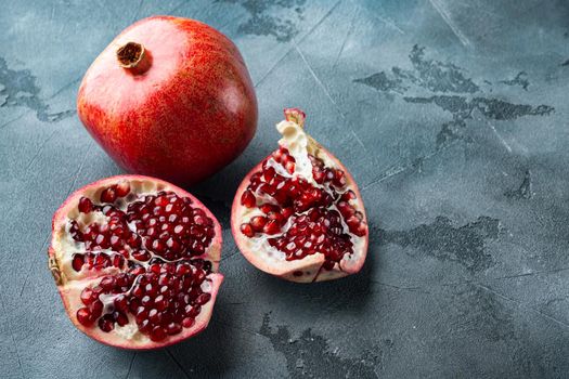 Ripe pomegranate with juicy seeds, on grey background with space for text