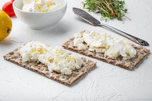 Crisp bread with cream cheese set, on white stone table background