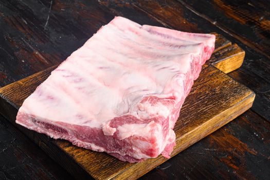 Raw Pork ribs set, on wooden cutting board, on old dark wooden table background