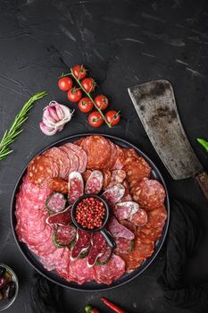 Spanish cold meat plate, chorizo, fuet, lomo,longaniza and salchichon on balck background, top view.