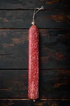 Salami sausage set, on old dark wooden table background, top view flat lay, with copy space for text