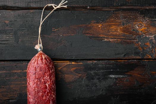 Sausage salami cured set, on old dark wooden table background, top view flat lay, with copy space for text